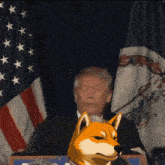 donald trump giving a speech in front of an american flag with a dog in front of him