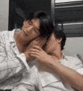 two men are hugging each other on a bed .