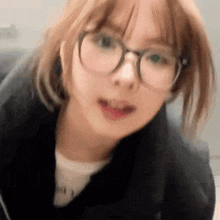 a close up of a girl wearing glasses and a jacket