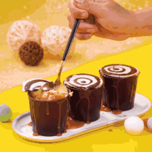 a person is pouring chocolate sauce into a cup