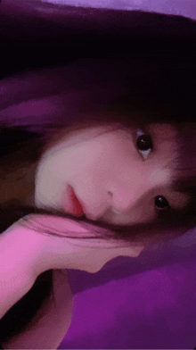 a close up of a woman 's face with purple hair