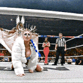 a woman in a white fur coat is kneeling down in a ring