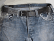 a pair of blue jeans with a black belt on them