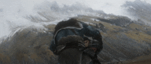 a man in a blue jacket is standing in front of a snowy mountain