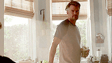 a man standing in front of a window holding a glass