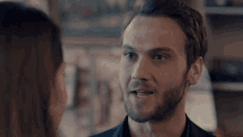 a man with a beard looks at a woman in a room