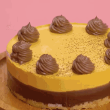 a cake with yellow frosting and chocolate frosting is on a wooden plate that says easy plus