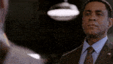 a man in a suit and tie looks at another man in a suit