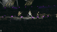 a group of people on a stage with the letter d on the bottom left