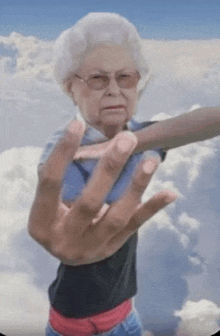 an elderly woman wearing glasses is making a stop sign
