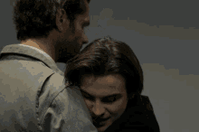a man with a beard is hugging a child and a woman