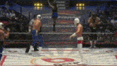 two wrestlers are fighting in a ring with a referee in the background .