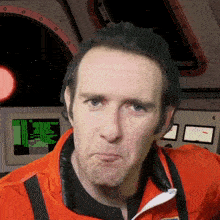 a man making a funny face in front of a screen that says ' a ' on it