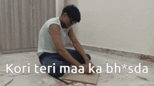 a man is kneeling on the floor with the words kori teri maa ka bh * sda above him