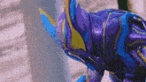 a close up of a purple and blue robot with a yellow horn