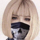 a woman with blonde hair is wearing a skull scarf around her face .