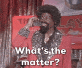 a man in a red suit is talking on a cell phone and says " what 's the matter " .