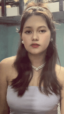 a young woman wearing a pearl necklace and earrings