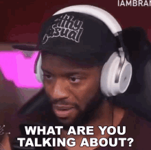 a man wearing headphones and a hat says " what are you talking about "