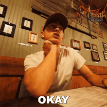 a man sitting at a table with the word okay written on the bottom