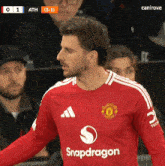 a man wearing a red shirt that says snapdragon on the front