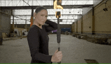 a woman in a black shirt is holding a torch