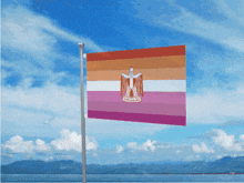 a flag with a cross on it is waving in the wind with mountains in the background