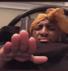 a man with a turban on his head is laying in bed and making a face .