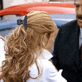 a woman with a clip in her hair is standing next to a man in a suit and tie