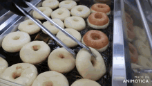 a bunch of donuts are being cooked in a pan that says made in animonica