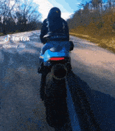 a person is riding a motorcycle down a road with a tik tok watermark