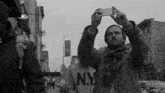 a man wearing a ny sweatshirt is taking a picture