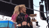 a woman holding a wrestling championship belt with the word alexa on her chest