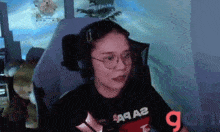 a woman wearing glasses and headphones is sitting in a gaming chair .