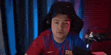 a man is sitting in a chair with his arms in the air wearing a rakuten jersey .
