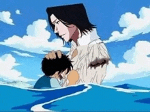 a man is standing next to a boy in the ocean .