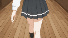 a girl in a pleated skirt is walking on a wood floor