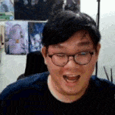 a man with glasses and a blue shirt is smiling