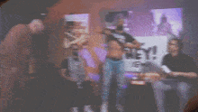 a shirtless man stands in front of a sign that says hey !