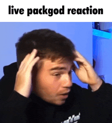 a man is holding his head with his hands and the words live packgod reaction are above him