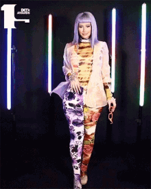 a woman with purple hair is standing in front of a bet awards sign