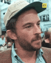 a man with a beard wearing a hat with the word et on the top