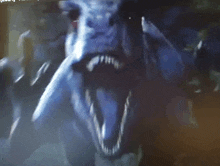 a close up of a monster 's face with a blurred background and a few words visible