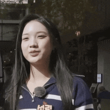 a woman wearing a blue and white striped shirt with the letter l on it