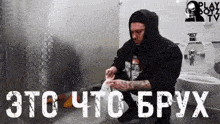 a man in a hoodie wipes his face in a public restroom with the words " это что брух " on the bottom