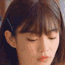 a close up of a young woman 's face with her eyes closed .