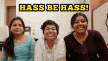 three women are smiling in front of a hass be hass sign