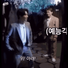 a man in a suit is standing next to another man in a white shirt with chinese writing on it .