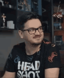 a man wearing glasses and a shirt that says head shot