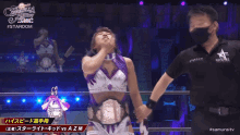 a woman in a purple and white wrestling outfit is being held up by a referee